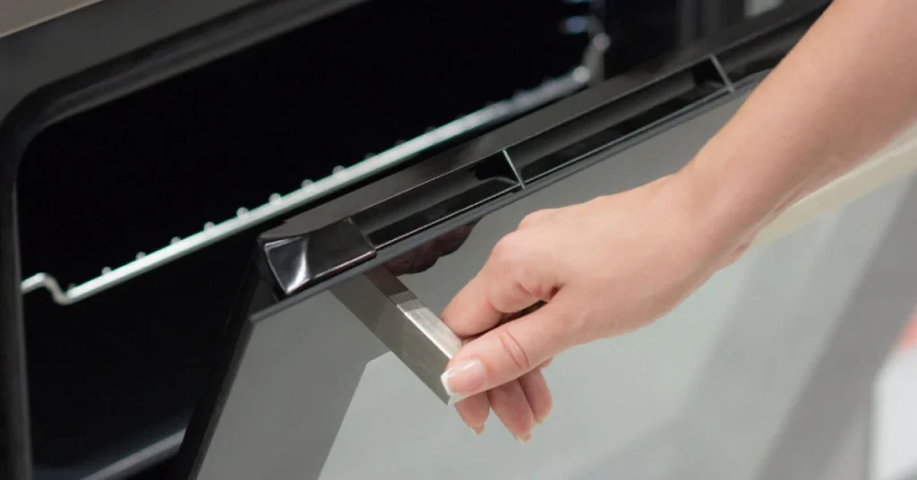 A person is trying to close the door of the oven