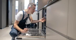 A professional technician is repairing a dishwasher